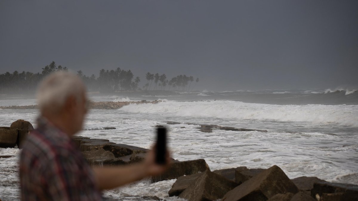 Una persona toma una fotografía al mar en Nagua (República Dominicana).