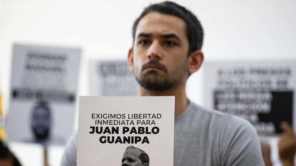 Ramón Guanipa sostiene un cartel de su padre detenido, Pedro Guanipa, en una imagen reciente.