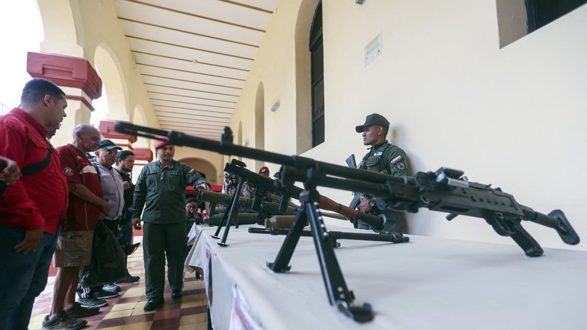 Un miembro de la guardia presidencial muestra armas durante una ceremonia de inducción para las personas que se enrolaron en la campaña de alistamiento de la Milicia Nacional Bolivariana.