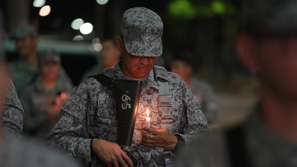 Un militar captado este domingo, 24 de agosto de 2025, al sostener una vela encendida, durante el 'velatón' por la paz y la memoria,