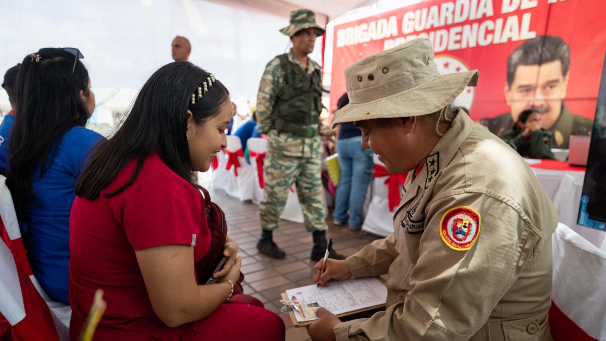 Un funcionario de la Milicia Bolivariana de Venezuela registra a una mujer durante una jornada de alistamiento este sábado, en Caracas (Venezuela).