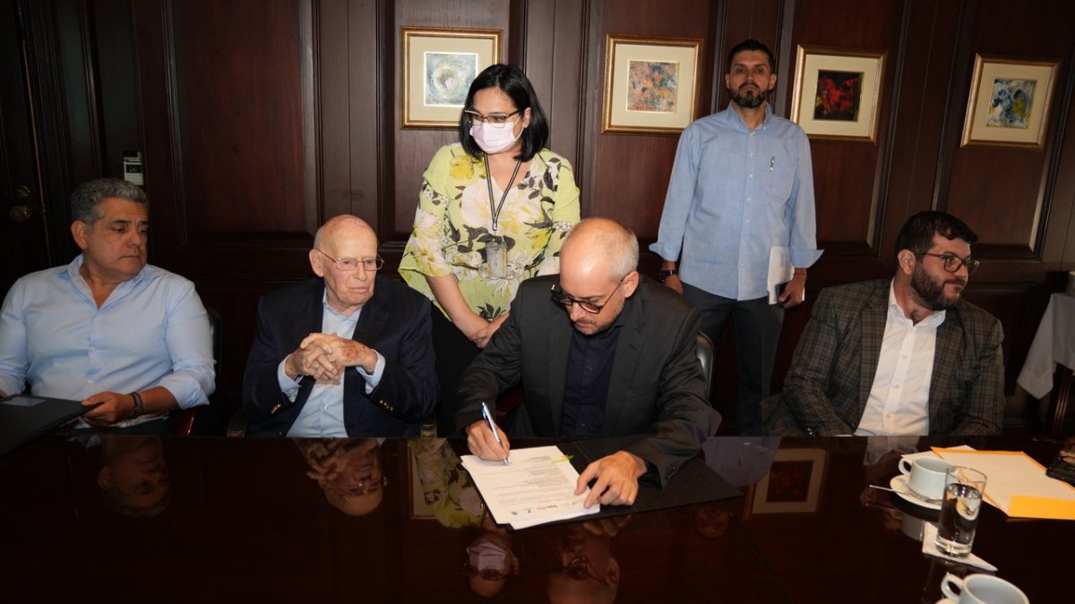 Representantes de TPG y de  la Cooperación Técnica Alemana GIZ firman un acuerdo.