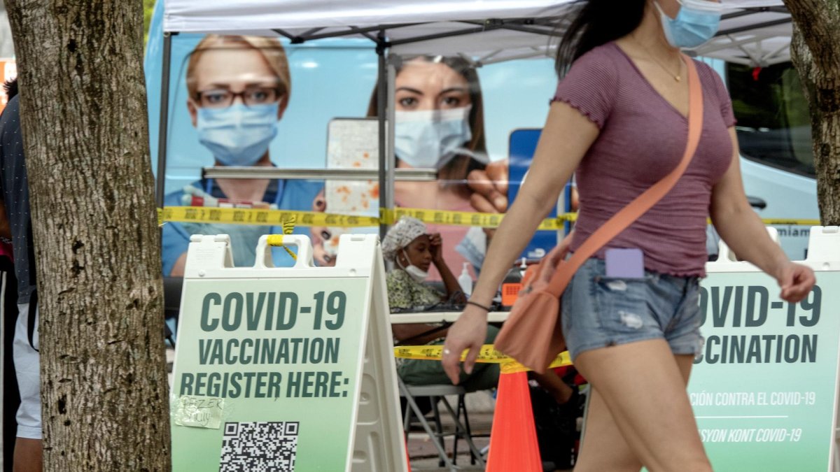 Personas caminan frente a un centro de vacunación contra la Covid-19.