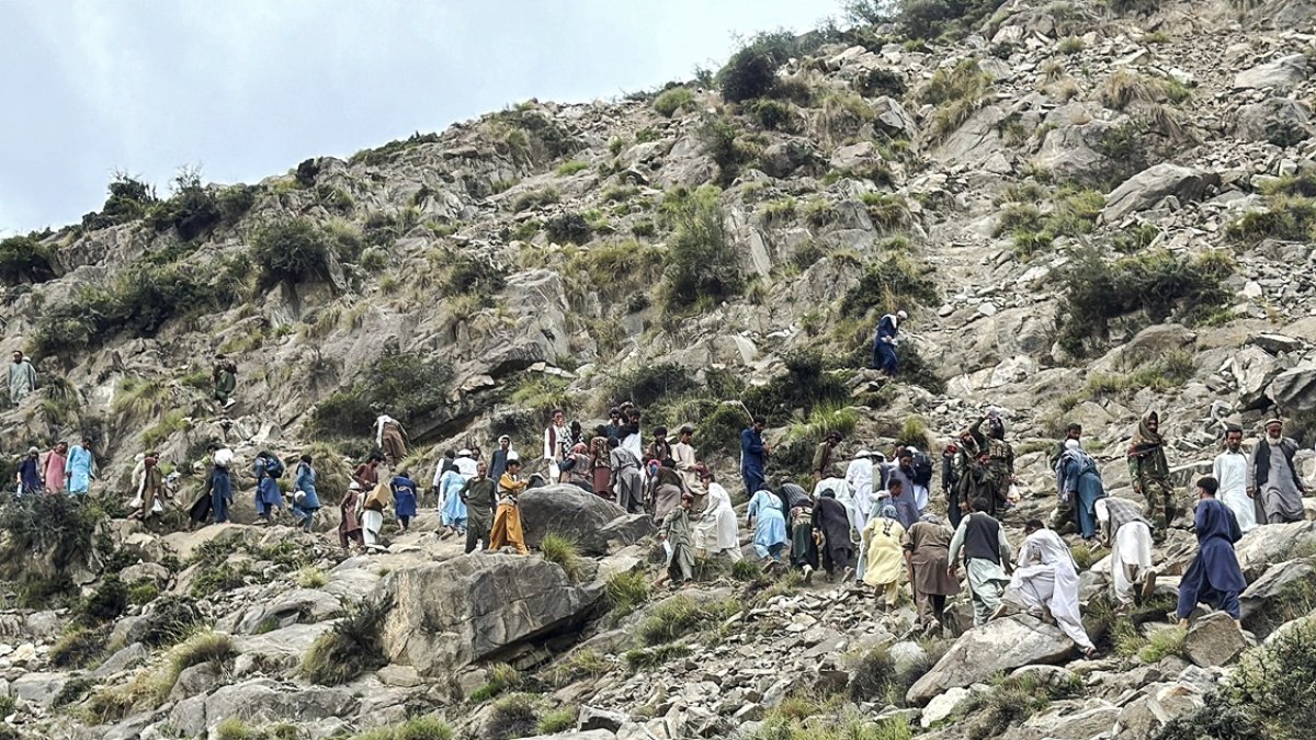 Voluntarios afganos caminan por una ladera, después de un terremoto en el distrito de Nurgal de la provincia de Kunar el 5 de septiembre de 2025.