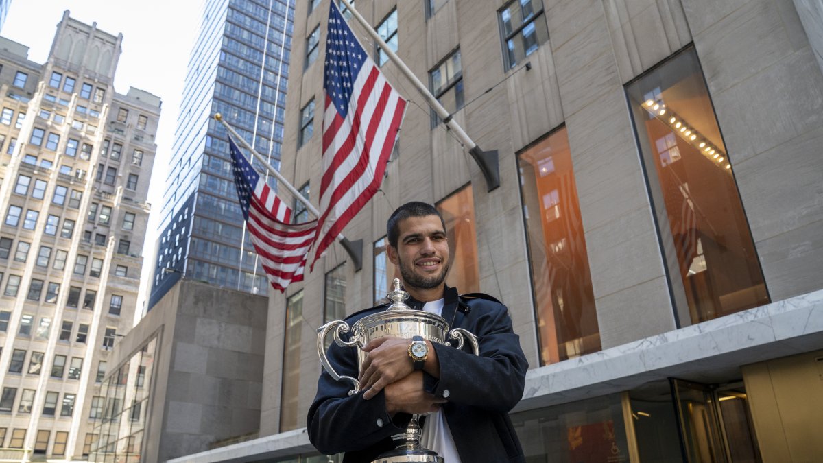 El tenista español Carlos Alcaraz, posa con el trofeo que lo acredita como campeón del Abierto de Estados Unidos 2025 este lunes, en el Rockefeller Center de Nueva York.