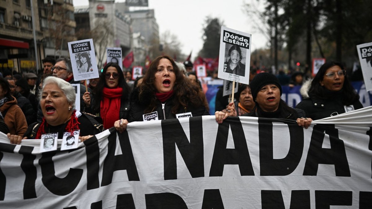 Manifestantes sostienen fotografías de personas desaparecidas para conmemorar el 52 aniversario del golpe militar de 1973 en Santiago, el 7 de septiembre de 2025.