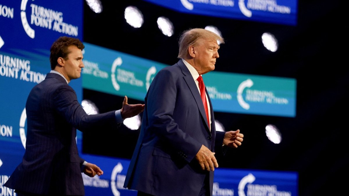 Donald Trump sube al escenario tras ser presentado por Charlie Kirk (izq.) en la conferencia Turning Point Action, el 15 de julio de 2023 en West Palm Beach, Florida.