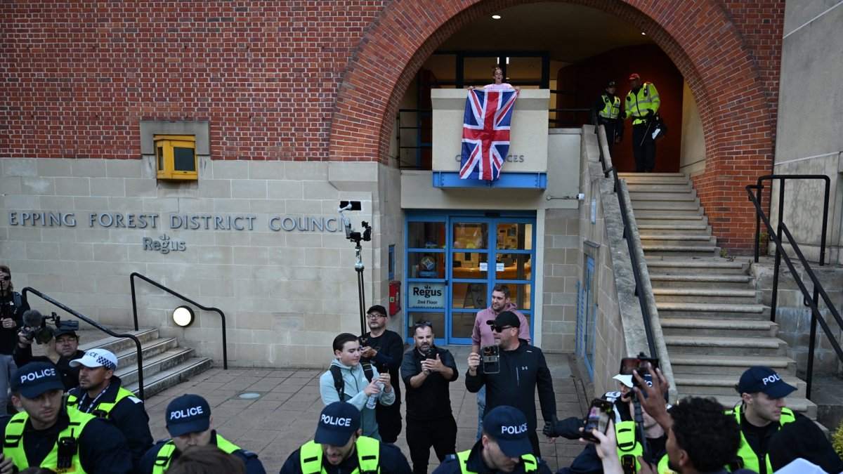 Un manifestante (arriba en el centro) es arrestado poco después de intentar colgar una bandera de la Unión afuera de las oficinas del consejo en Epping, al noreste de Londres.