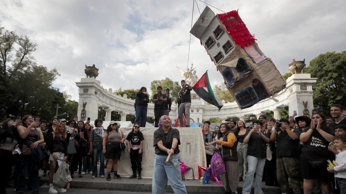 Una persona golpea una piñata durante una manifestación contra la gentrificación este domingo, en Ciudad de México (México).