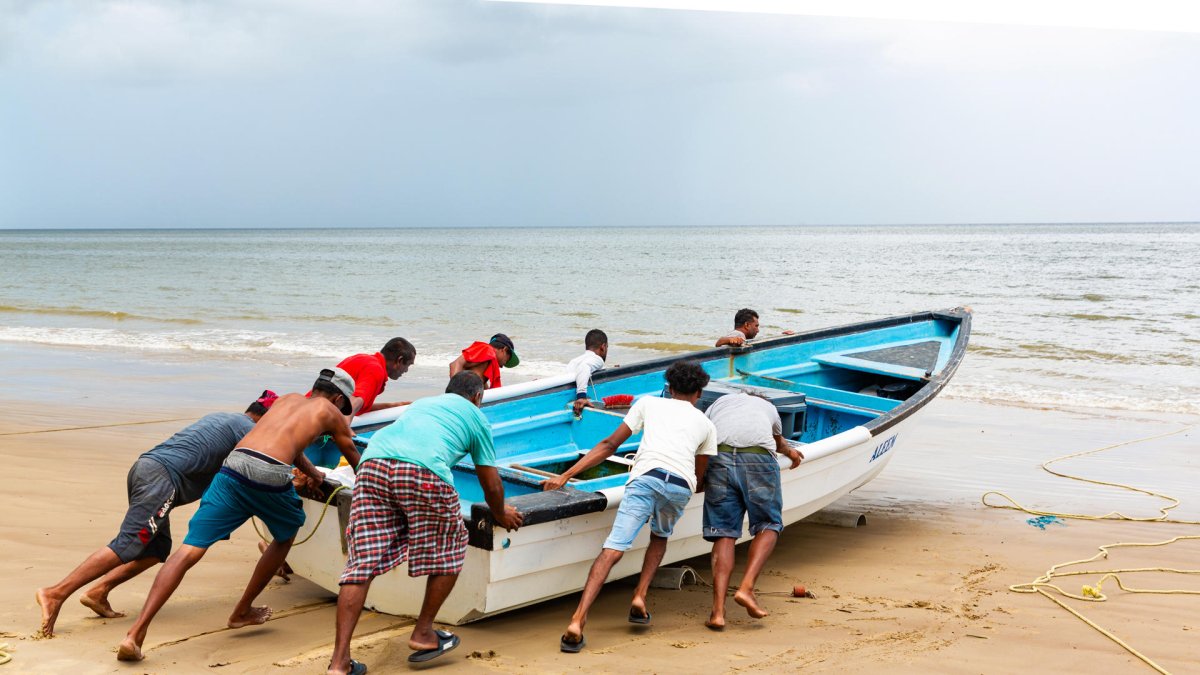 Foto de referencia de pescadores empujando una embarcación el 10 de septiembre de 2025.
