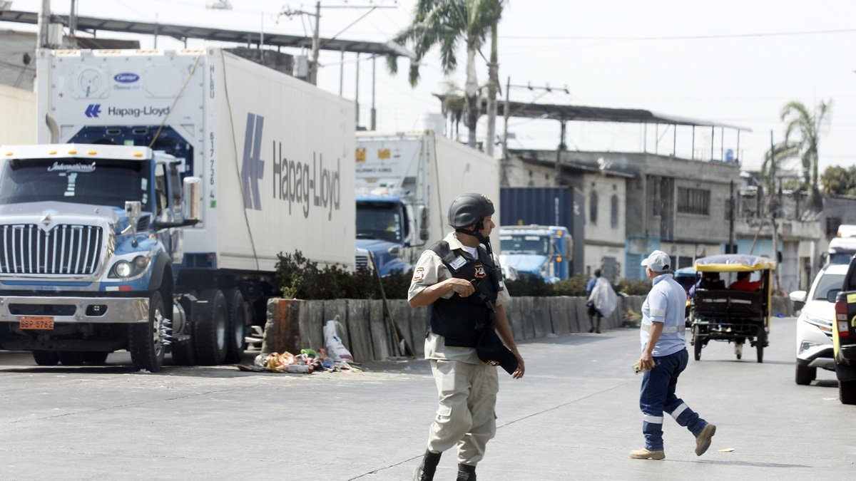 Guardias de seguridad de las terminales de la isla Trinitaria custodian las cargas que llegan.