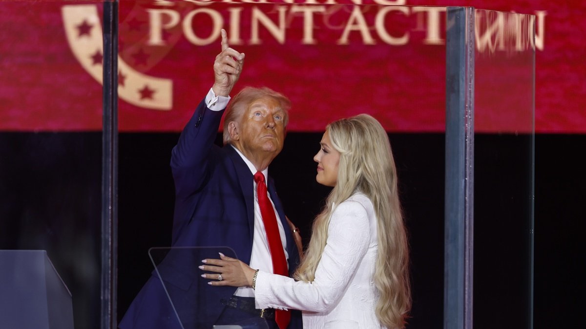 El presidente de EE. UU., Donald Trump y Erika Kirk, esposa de Charlie Kirk, se abrazan en el escenario durante el servicio funerario conmemorativo del activista en Glendale, Arizona.