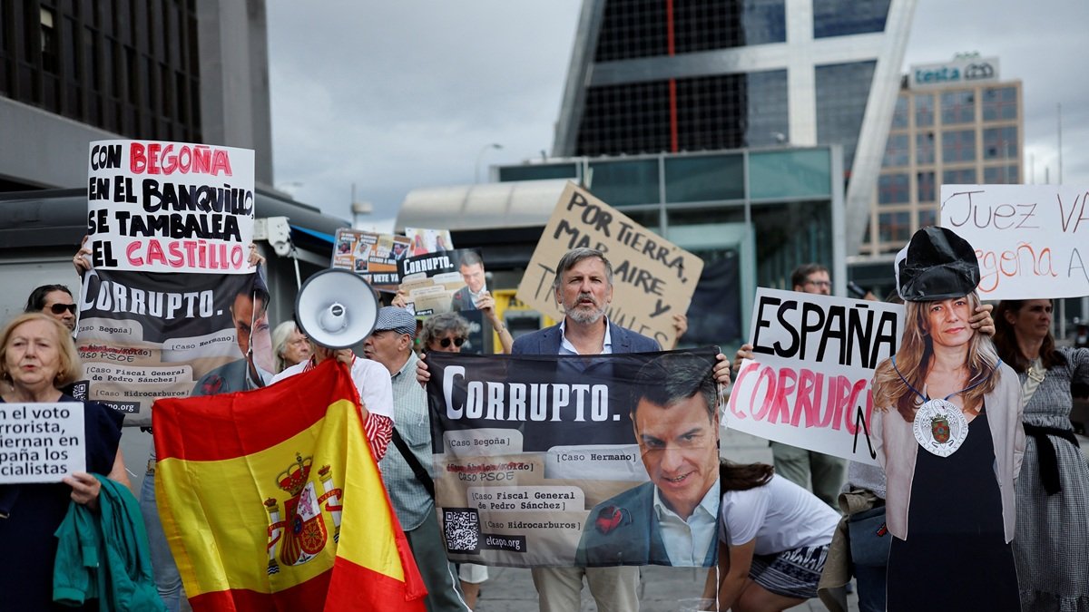 Los manifestantes sostienen una efigie de Begoña Gómez y una pancarta que dice 