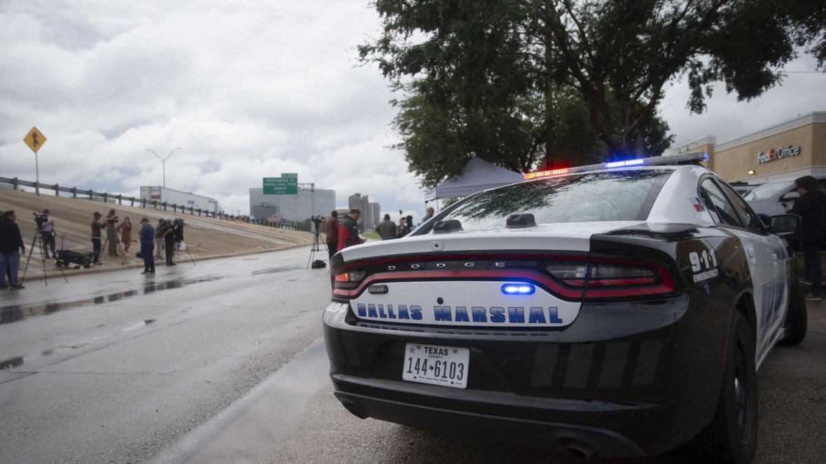 Un auto de la Policía de Dallas aparcado tras un tiroteo en la oficina local del Servicio de Inmigración y Control de Aduanas (ICE), en Dallas, Texas, EE.UU.