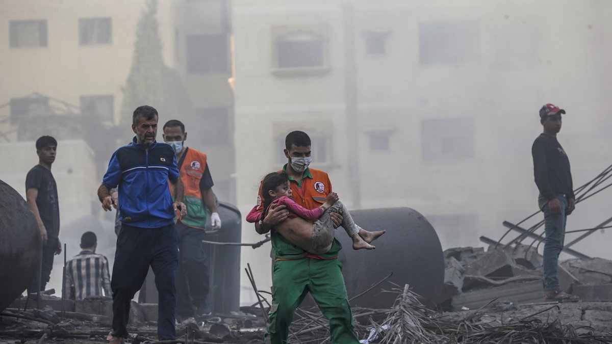 Un palestino carga a una niña herida tras recuperarla de los escombros de una zona destruida tras los ataques aéreos israelíes en la ciudad de Gaza.