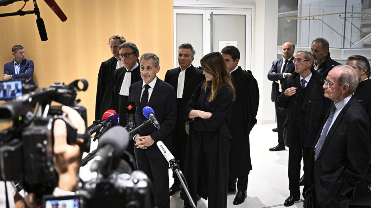 El ex presidente Nicolas Sarkozy habla con la prensa flanqueado por su esposa Carla Bruni y el abogado Jean-Michel Darrois, en el tribunal del Tribunal de París, el 25 de septiembre de 2025.