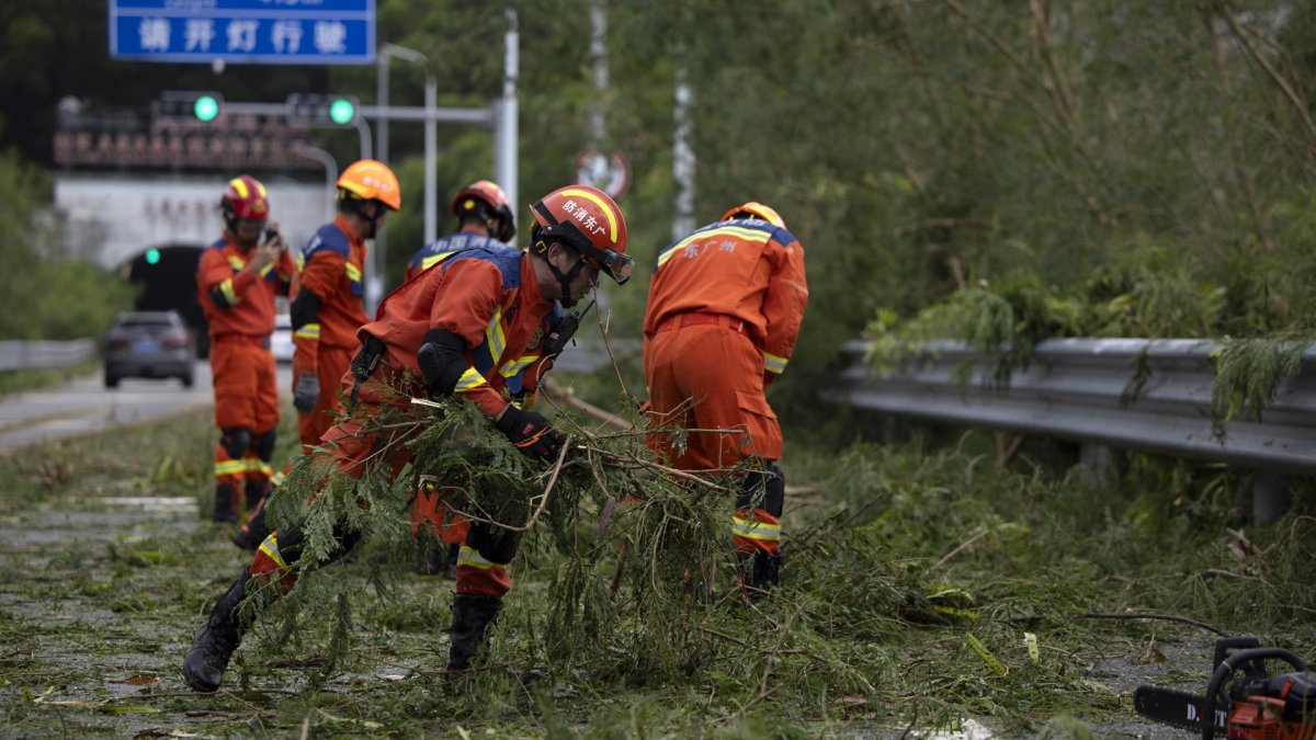 Bomberos limpian una carretera de ramas de árboles después del paso del tifón Ragasa en la isla Hailing,provincia de Guandong, China, el 25 de septiembre de 2025.