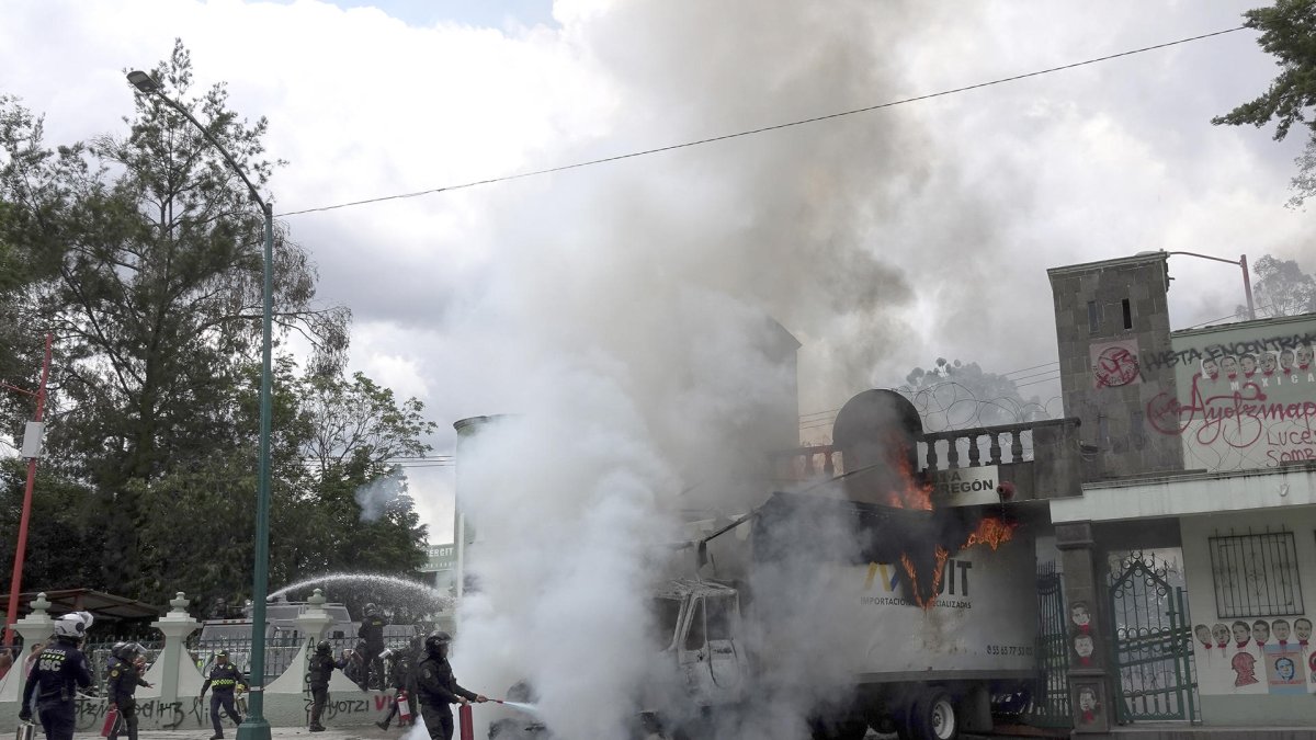 Policías intentan sofocar el fuego de un camión vandalizado en las instalaciones del Campo Militar en la Ciudad de México (México).