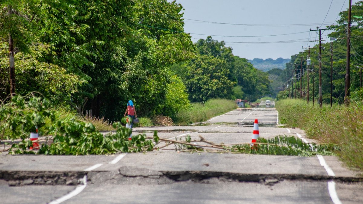 Una mujer camina junto a carretera dañada un día después de que un terremoto de magnitud 6,3 sacudiera la ciudad de Mene Grande en el estado Zulia, el 25 de septiembre de 2025.