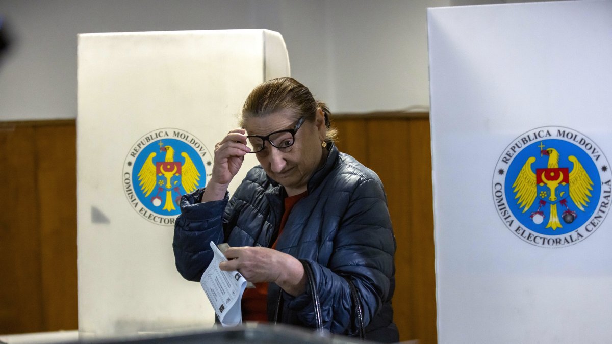 Una mujer deposita su voto en un colegio electoral.
