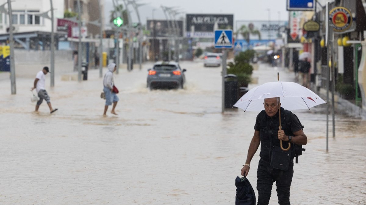 Personas caminando por una calle inundada en Ibiza, el 30 de septiembre de 2025.