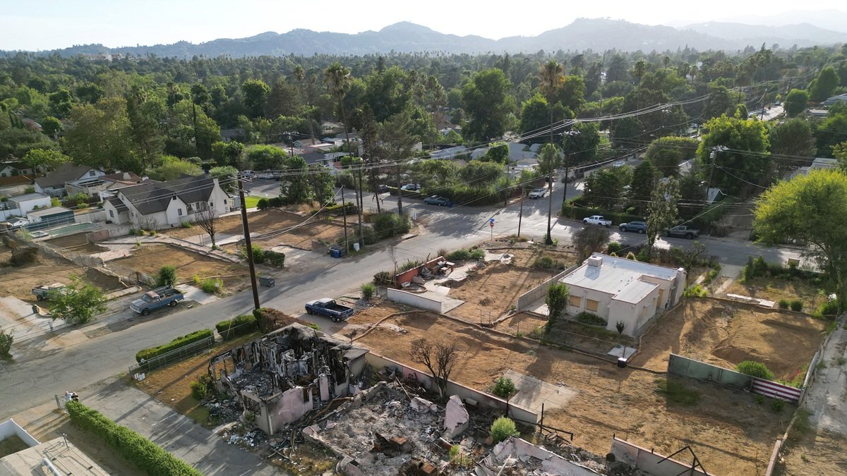 Lotes residenciales despejados después de que las casas allí fueran destruidas en el incendio de Eaton de enero de 2025, junto a casas que aún están en pie, en Altadena, California.