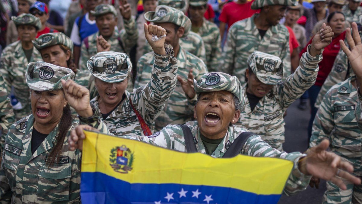 Una integrante de la Milicia Bolivariana sostiene una bandera durante una movilización en apoyo al gobierno nacional este lunes, en Caracas (Venezuela).