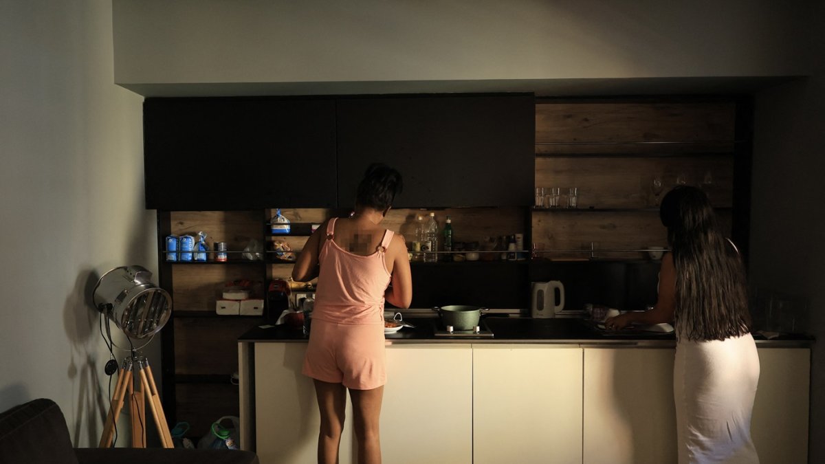 Ana y María, (nombres ficticios), víctimas de trata sexual procedentes de América Latina, lavan platos en Tirana el 1 de agosto de 2025.