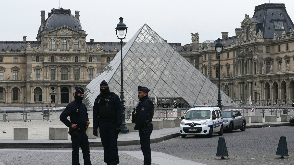 Agentes de policía franceses se sitúan frente al Museo del Louvre tras un robo, en París, este domingo 19 de octubre de 2025.