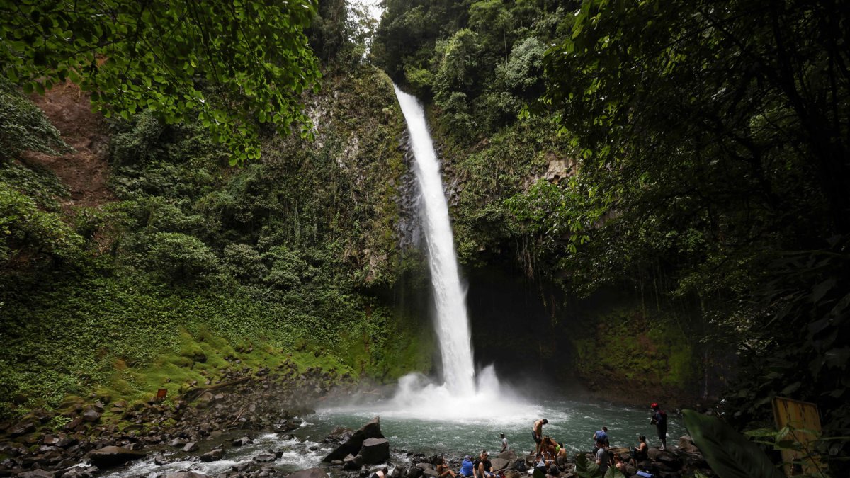 Fotografía del 3 de octubre de 2025 de un grupo de turistas en la catarata La Fortuna en los alrededores del volcán Arenal en la Fortuna (Costa Rica).