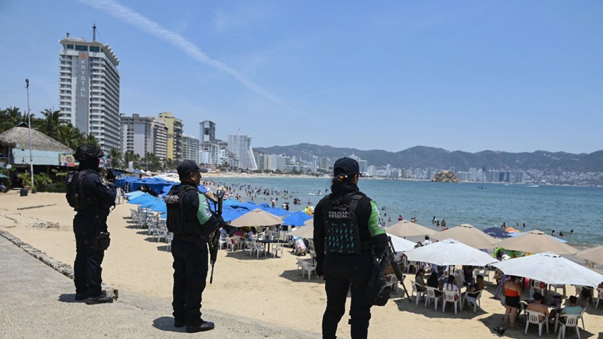 Agentes de la policía estatal patrullan una playa como parte de un operativo de seguridad para prevenir actos delictivos ante una ola de violencia y proteger a los turistas.