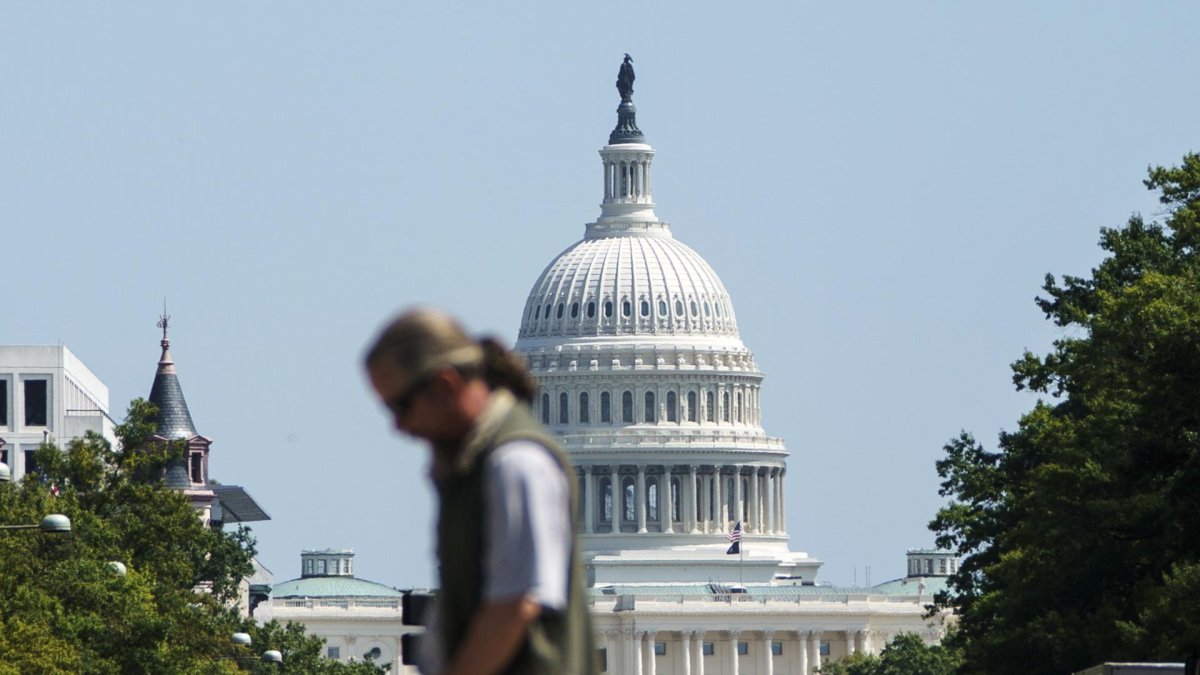Un transeúnte cruzando la avenida Pensilvania frente al Capitolio de los Estados Unidos, en Washington D. C..