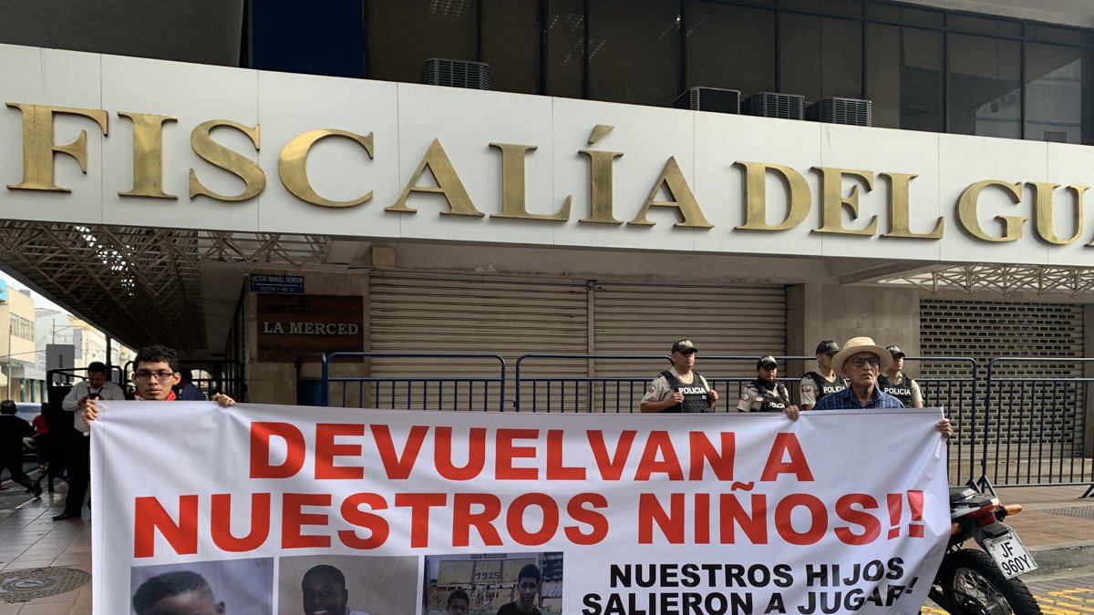 Archivo del 23 de diciembre de 2024 que muestra dos personas sosteniendo un cartel en los exteriores de la Fiscalía Provincial del Guayas.