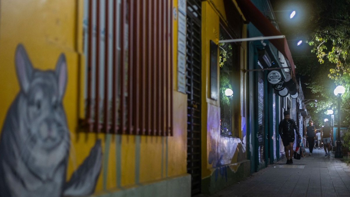 Una persona camina por la acera frente a comercios cerrados en el barrio Italia, distrito de Providencia, Santiago. 30 de octubre de 2025.