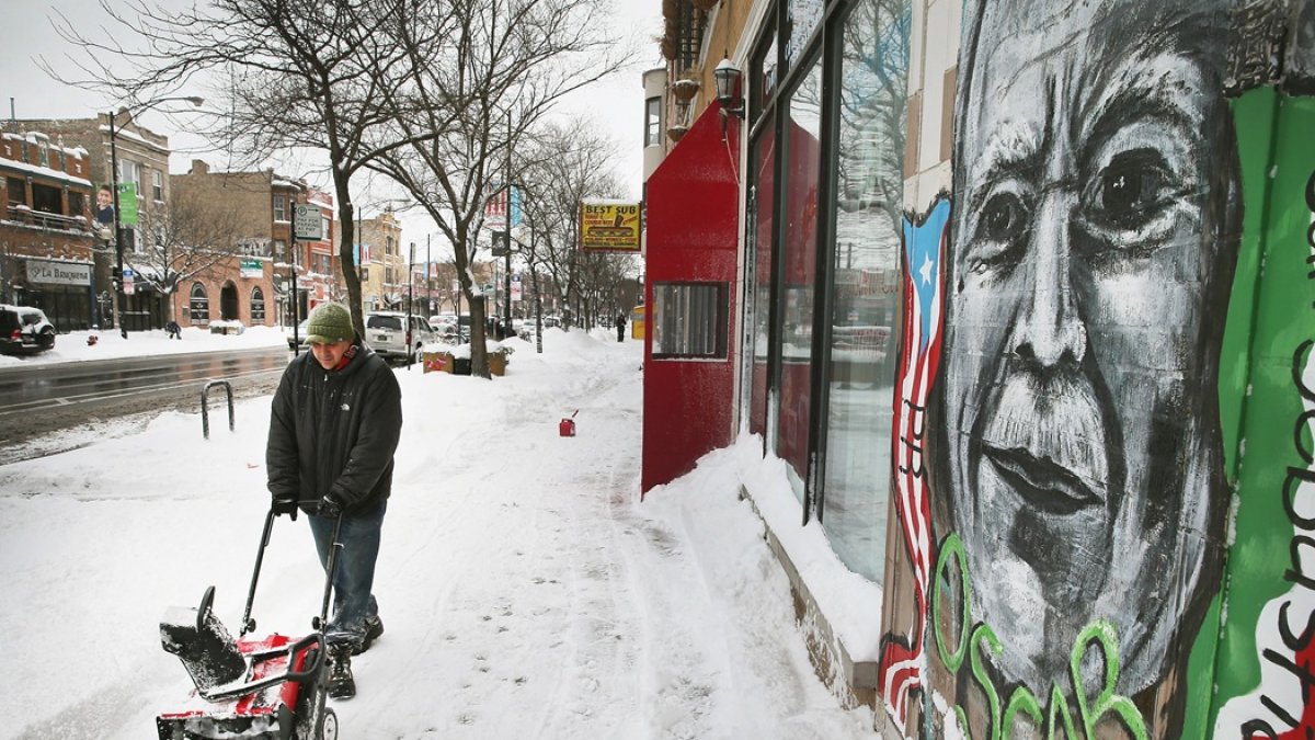 Una persona quita la nieve del frente de la escuela secundaria puertorriqueña Dr. Pedro Albizu Campos en el vecindario de Humboldt Park en Chicago, Illinois.