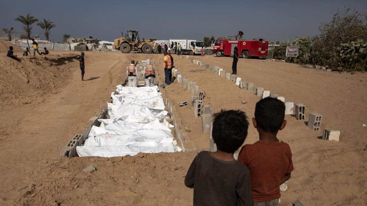 Los restos y cuerpos de palestinos no identificados, devueltos por Israel, son colocados en una fosa común en el centro de la Franja de Gaza, el 10 de noviembre de 2025.