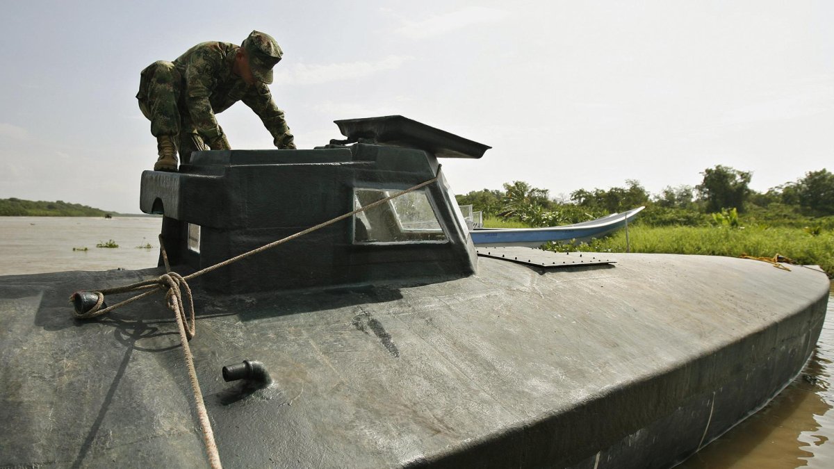 Fotografía de un soldado de la Armada Nacional de Colombia al inspeccionar un submarino utilizado por grupos delictivos.