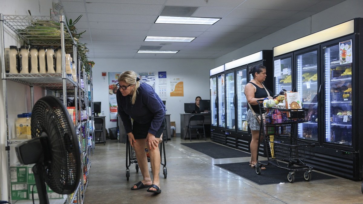 Deysi Camacho (izq.) y Maria Calderon realizan sus compras el 27 de octubre de 2025 en Pembroke Park, Florida.