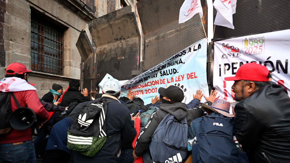 Integrantes de la Coordinadora Nacional de Trabajadores de la Educación (CNTE), se manifiestan afuera del Palacio Nacional de la Ciudad de México (México).