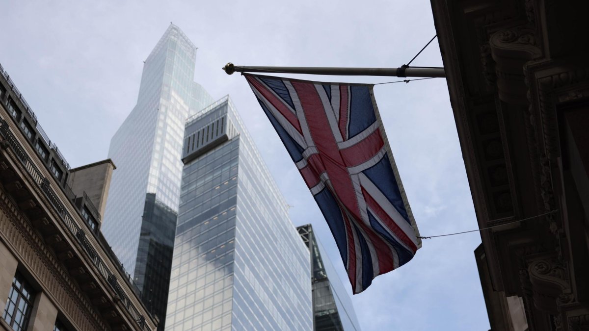 Una bandera Union Jack ondea entre edificios altos y antiguos en el distrito financiero de la City de Londres, Gran Bretaña, el 13 de noviembre de 2025.