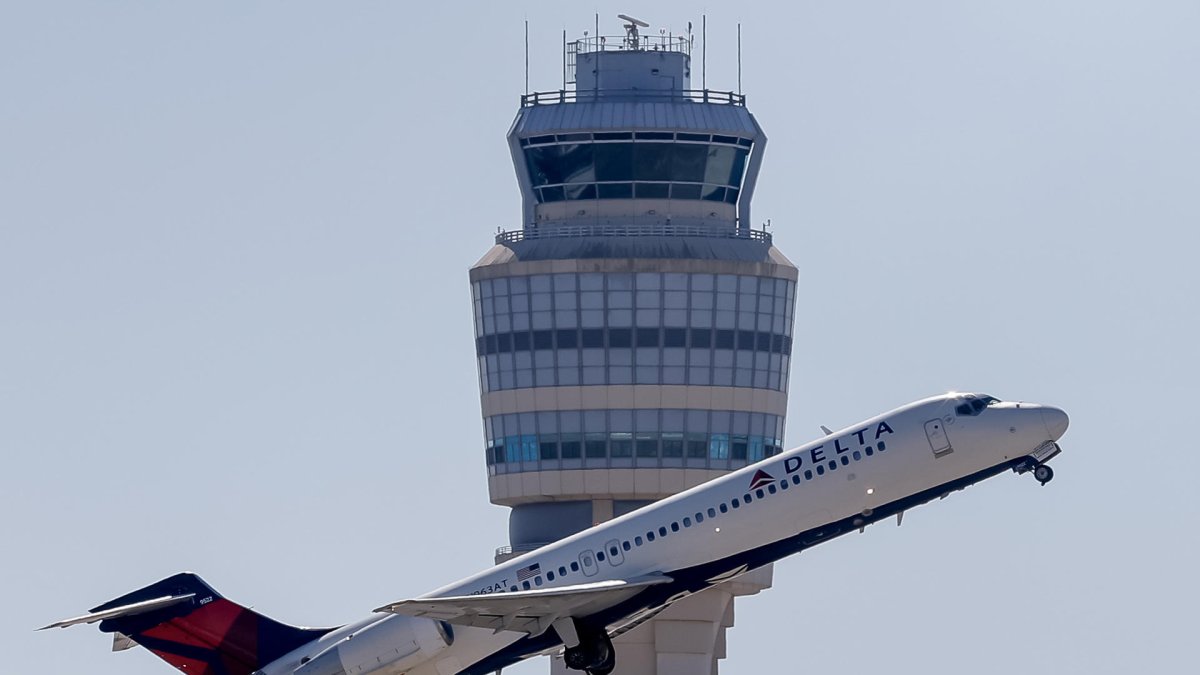 Fotografía de un avión Delta Air Lines pasando por la torre de control del Aeropuerto Internacional Hartsfield-Jackson, en Atlanta (Estados Unidos).