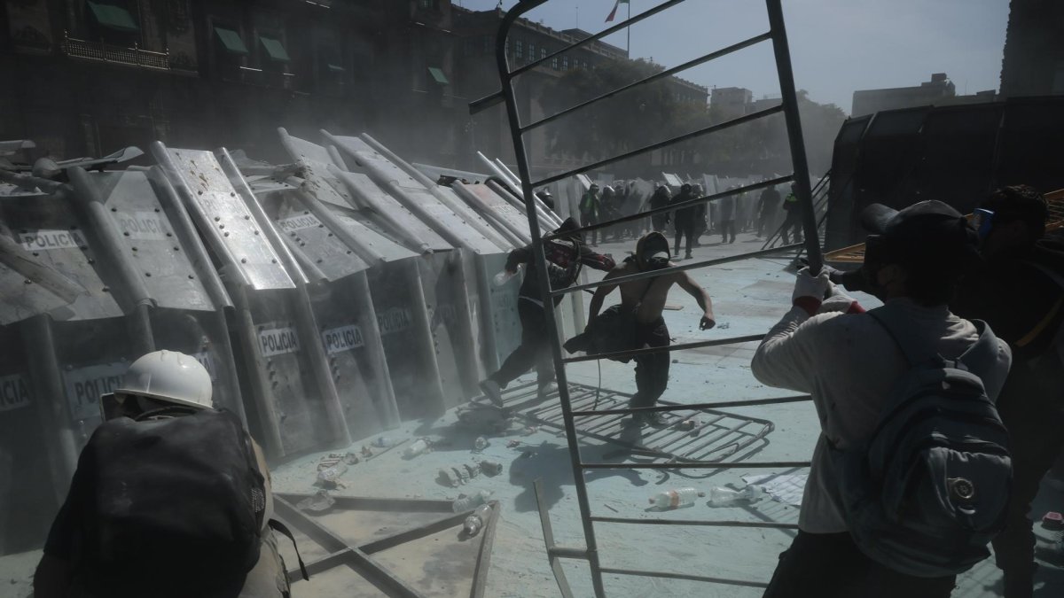 Manifestantes se enfrentan con integrantes de la policía en una protesta en inmediaciones del Palacio Nacional en Ciudad de México (México).