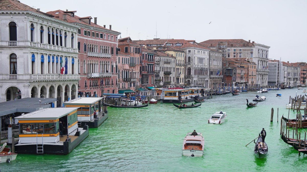 Una foto publicada por Rebelión contra la Extinción muestra a activistas tiñendo de verde el Gran Canal de Venecia durante una protesta en Venecia.