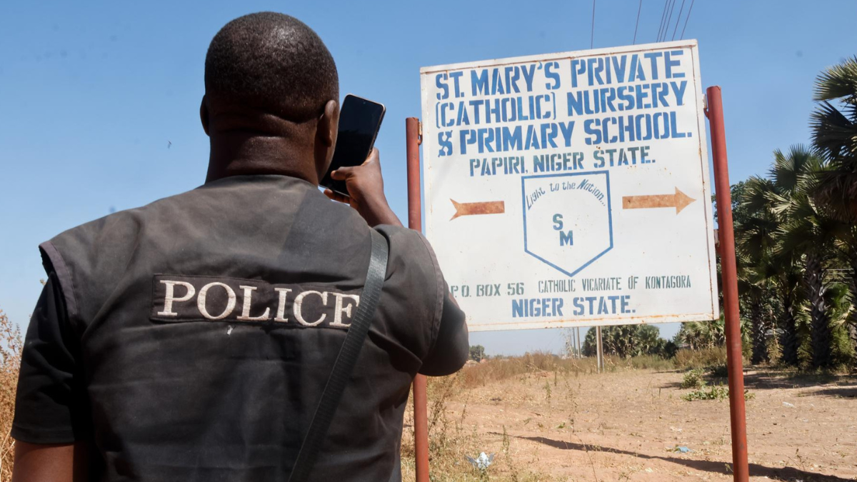 Un miembro de las fuerzas de seguridad toma fotografías del letrero de la Escuela Católica Privada St. Mary's en Papiri, estado de Níger, Nigeria