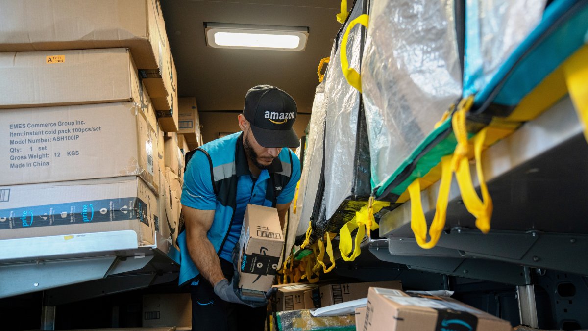 Un trabajador de la empresa Amazon organiza paquetes que se deben entregar.