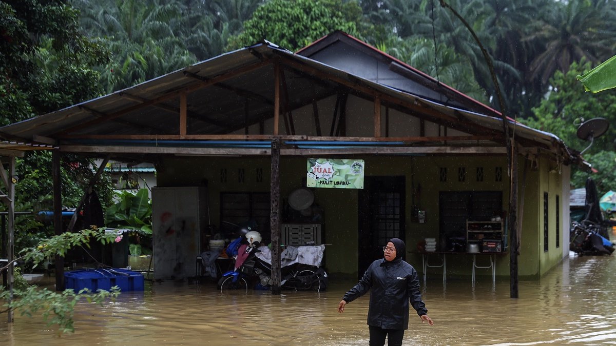 Una mujer camina por las aguas inundadas en Klang, en las afueras de Kuala Lumpur, Malasia, este lunes 24 de noviembre de 2025.