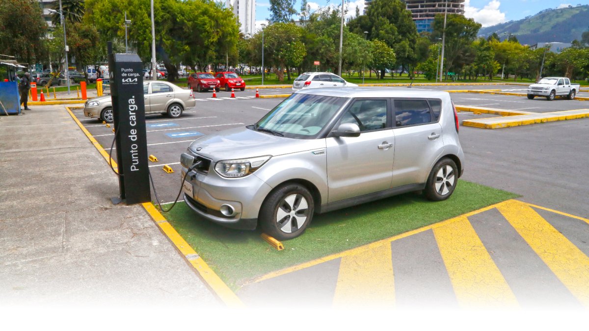 Un carro eléctrico se carga de energía en un parqueadero.