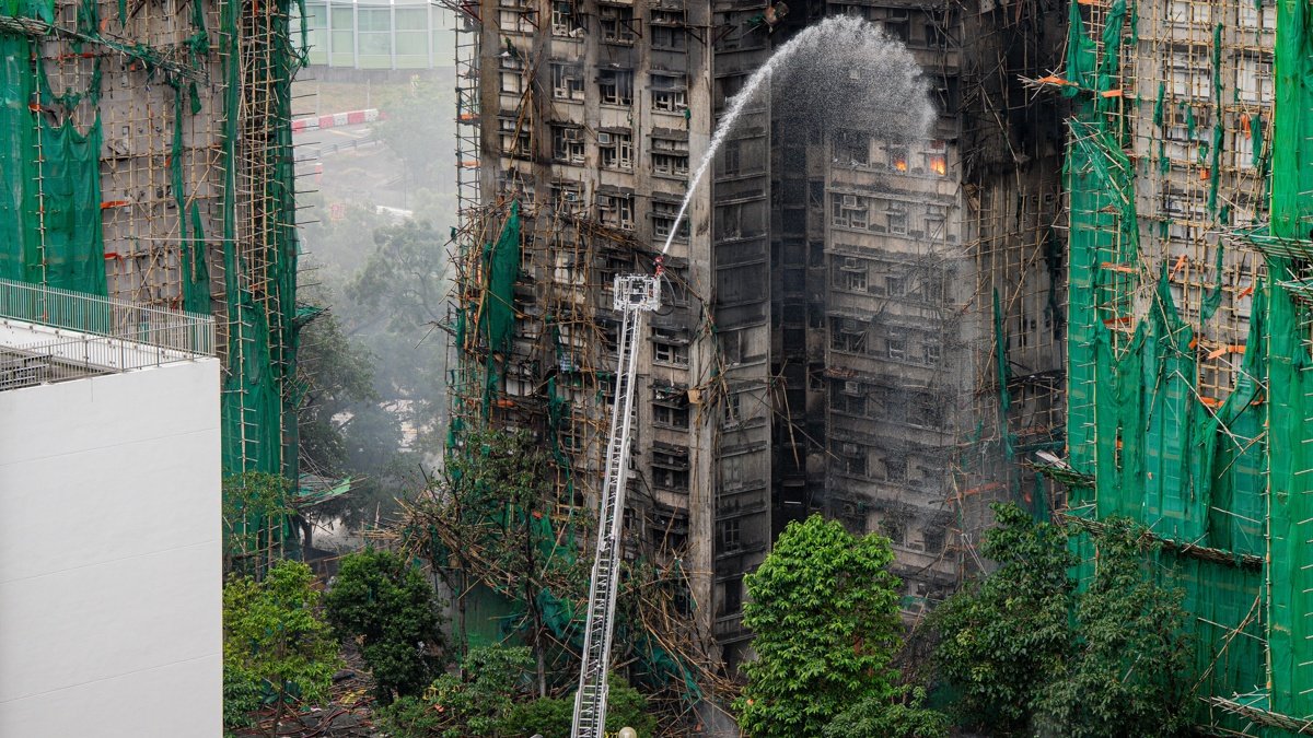 Los bomberos rocían agua sobre un apartamento en llamas en el distrito de Tai Po de Hong Kong, China, el 27 de noviembre de 2025.
