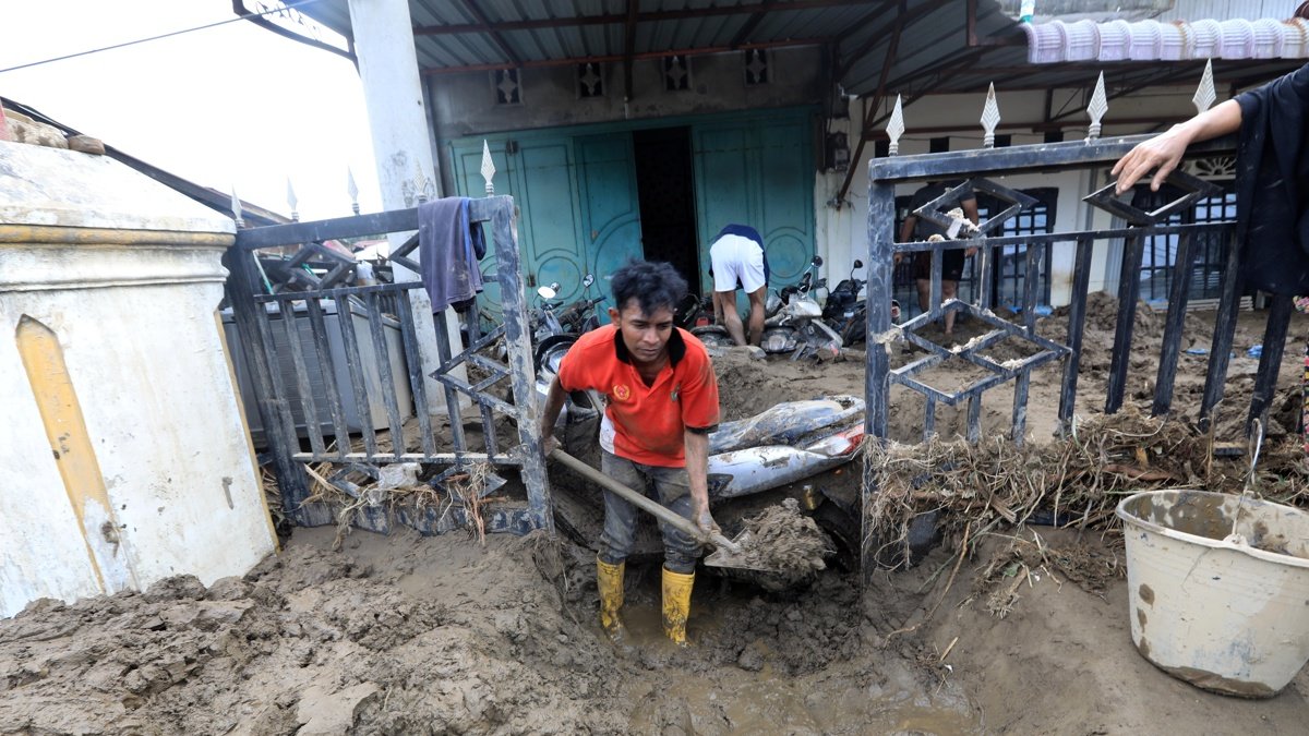 Residentes intentan limpiar su casa del barro en la zona de Meureudu , en banda Aceh, Indonesia.