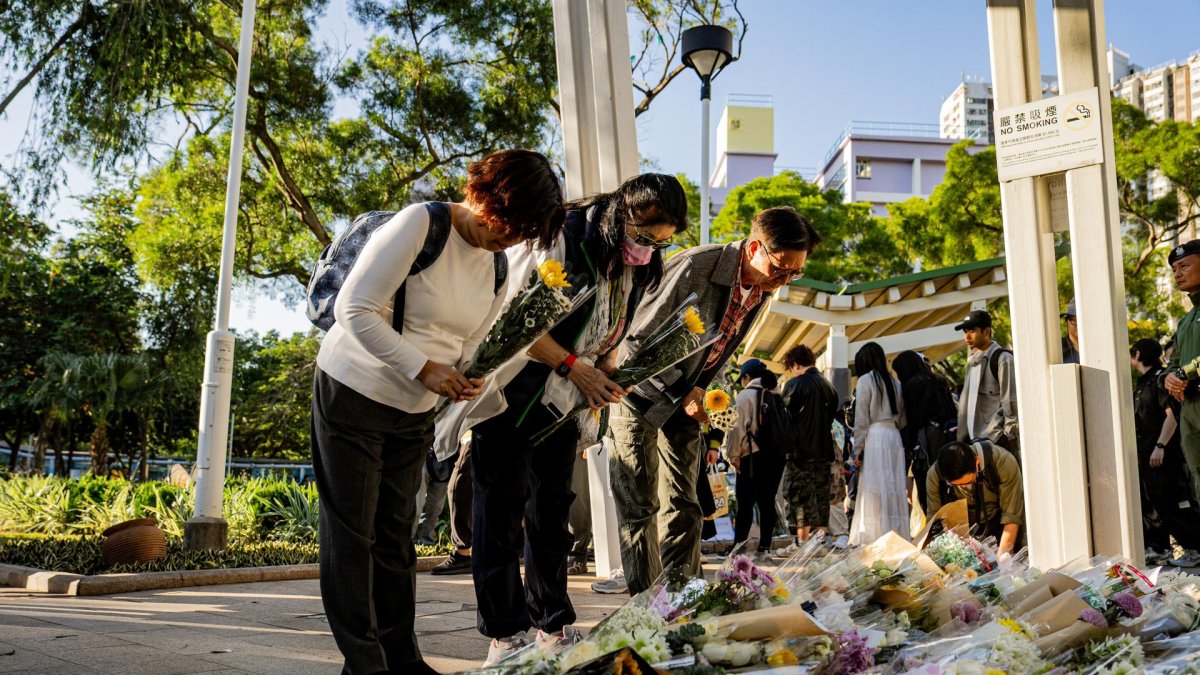 Multitud de personas depositan ofrendas florales en memoria de las víctimas del incendio en el complejo residencial Wang Fuk Court, Hong Kong, China, el 29 de noviembre de 2025.